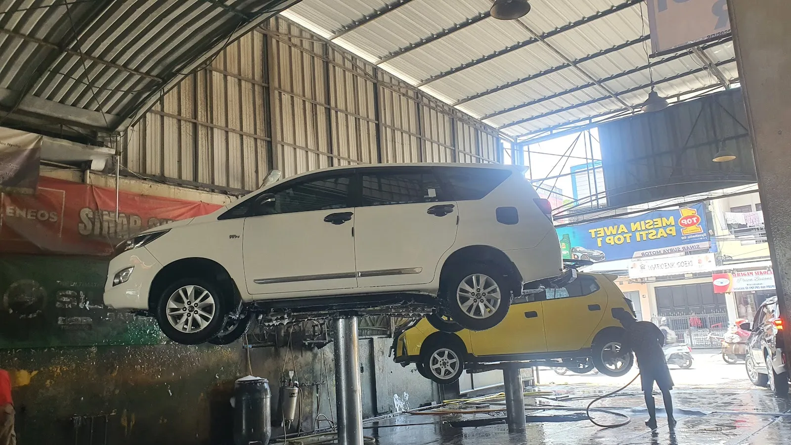 Mobil diangkat lift hidrolik saat dicuci di Sinar Surya Auto Care Bojongsoang, Bandung